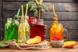 front-close-view-organic-fresh-juices-bottles-served-with-tubes-fruits-wooden-cutting-board-brown-table_140725-94487.jpg